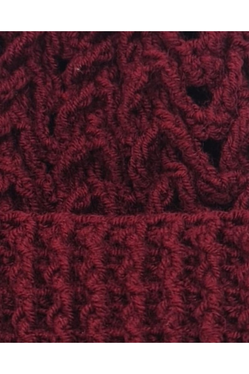 Close-up detail of textured crochet pattern on a burgundy handmade beanie