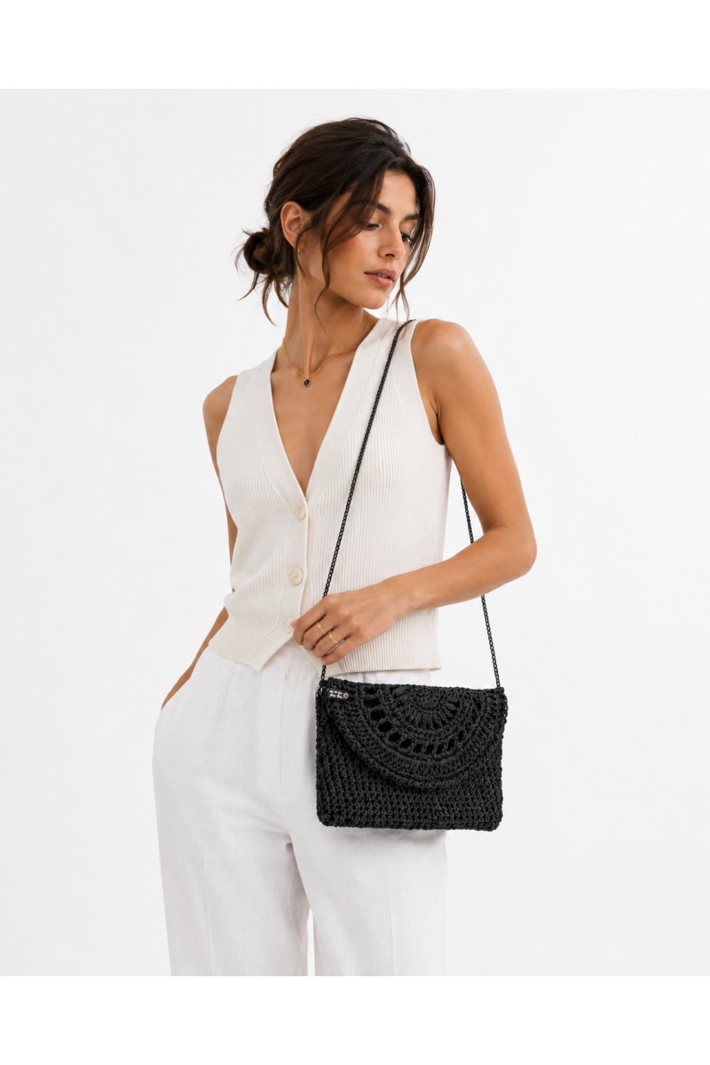 Elegant fashion model wearing a handmade black raffia crossbody bag by Grace Note Made in Greece
